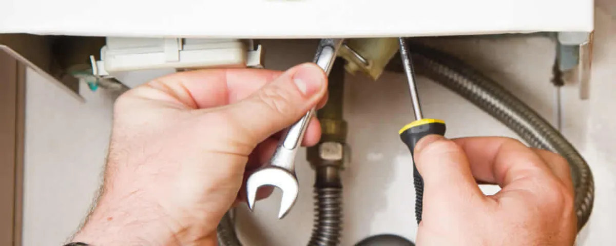 Boiler repair technician tightening pipe fittings and connections in Mansfield, MA